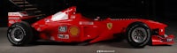 a red ferrari racing car is parked in a garage