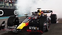 a red bull racing car with smoke coming out of it